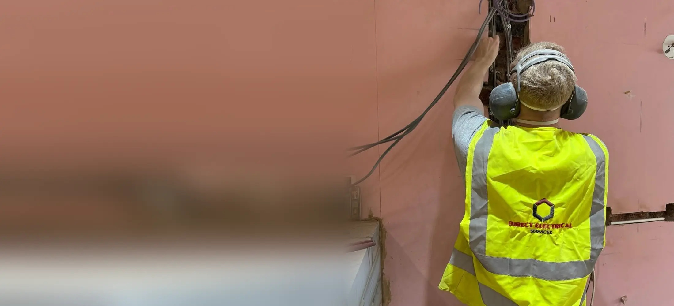 Direct Electrical Services electrician first fixing cables into a chased wall
